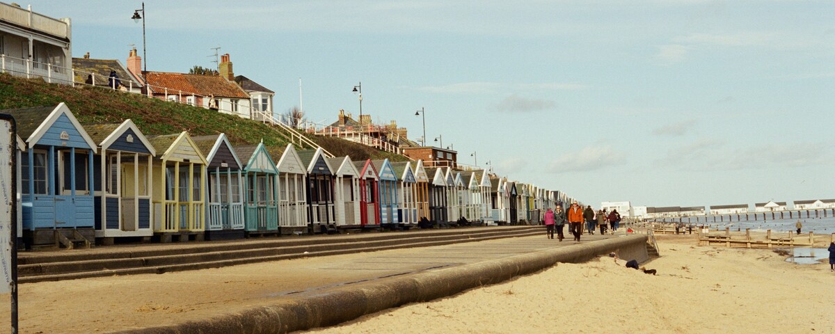 A row of pastel beach huts along the promenade at Southwold