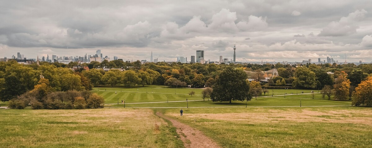 The London skyline seen from the top of Primrose Hill, one person on the path