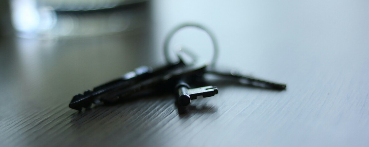 A set of keys left on a table beside a rain-streaked window