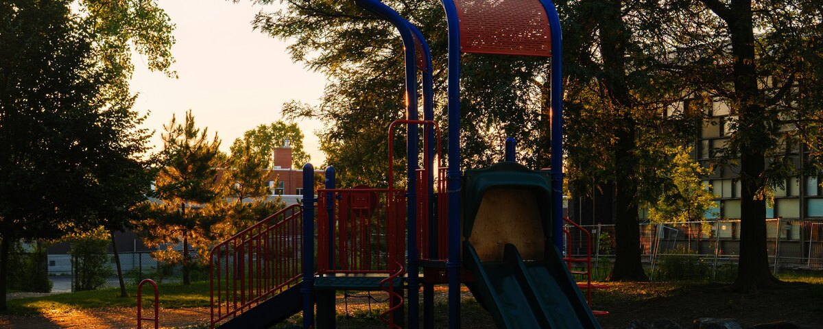 An empty playground frame in late golden light