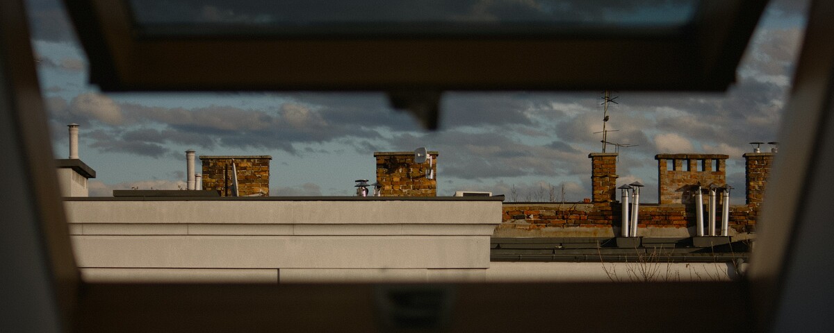 Rooftops and a grey sky seen through an open window